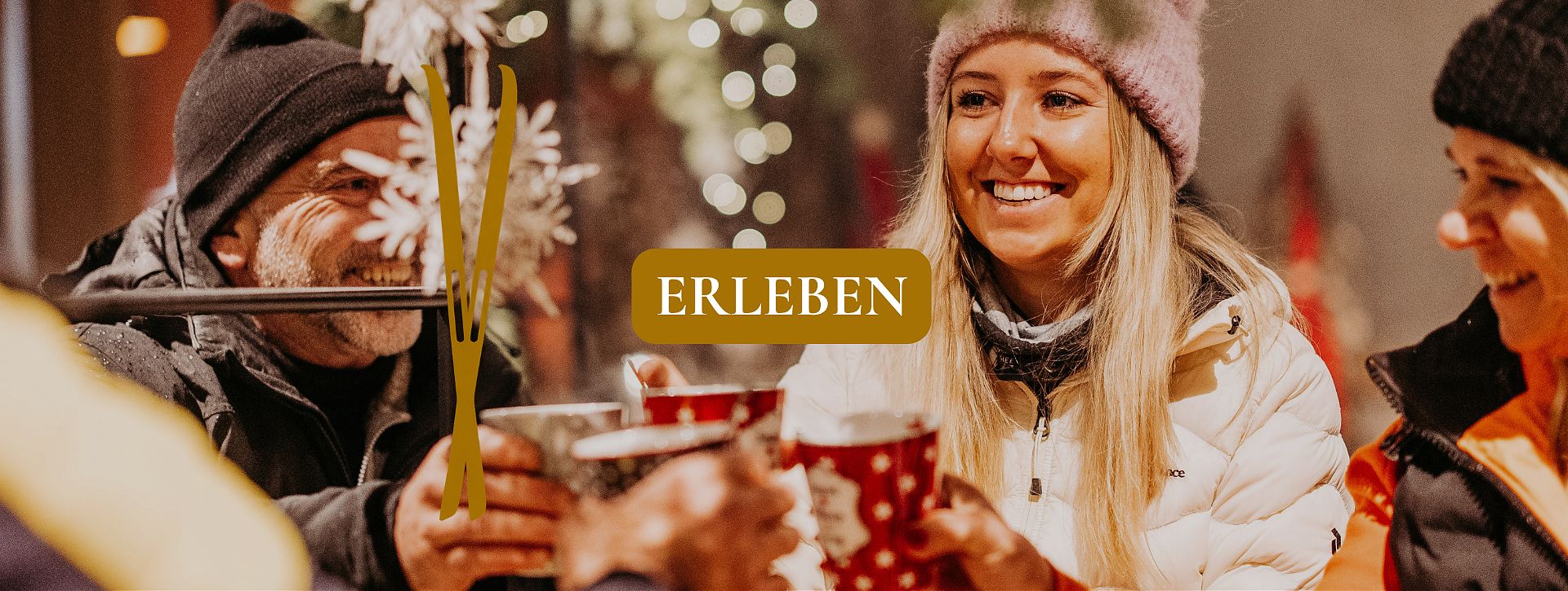 Drei Personen stoßen in winterlicher Atmosphäre mit Heißgetränken an, ergänzt durch die Beschriftung „Erleben“.
