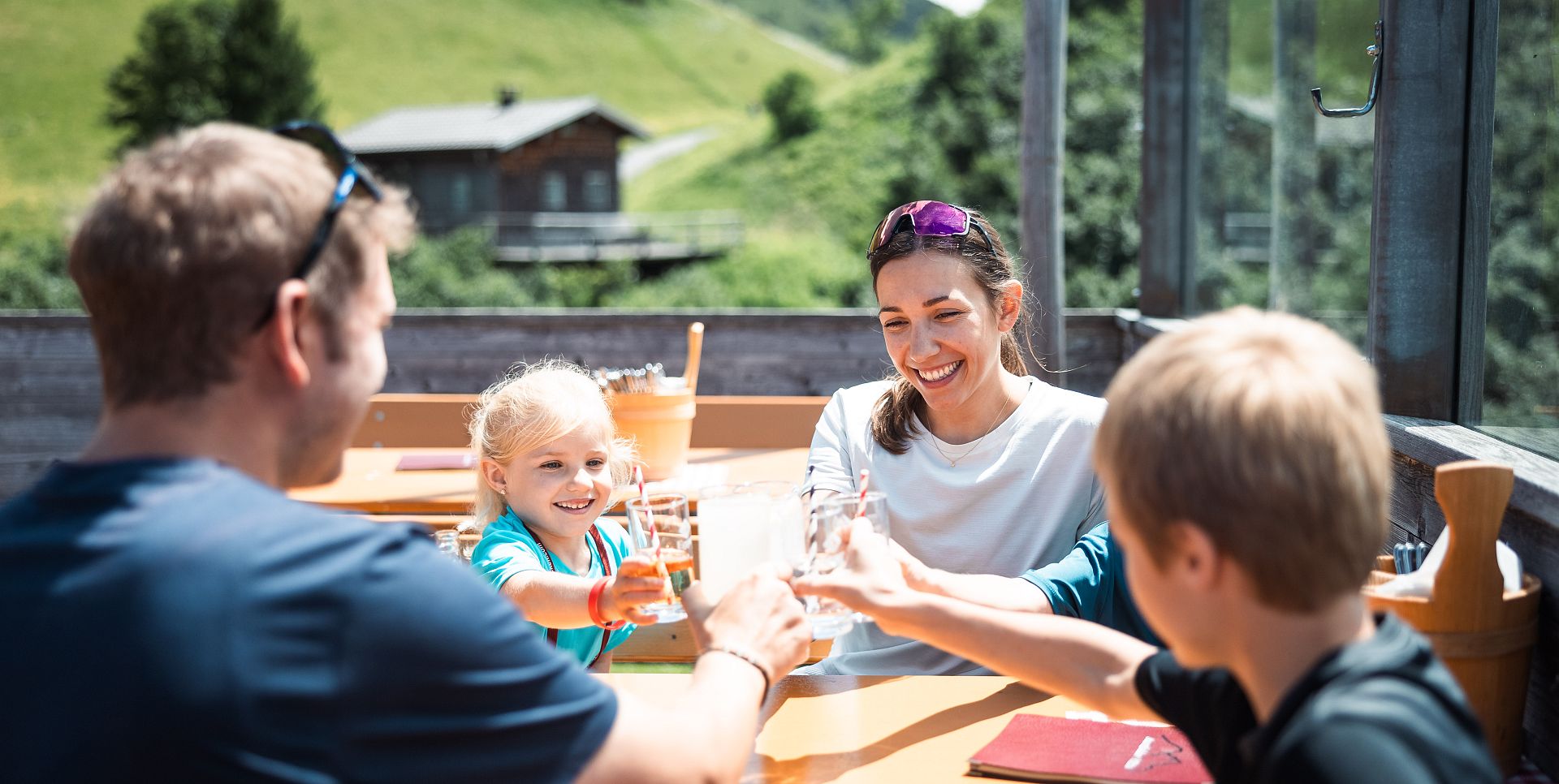 A family raises a toast with a cold drink at the Auenfelder Hut.