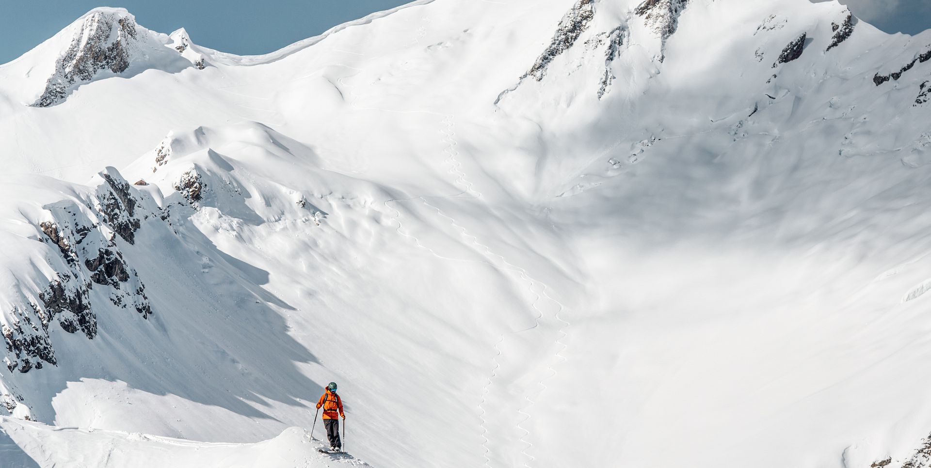 Ein Skifahrer steht vor dem Freeriderun, umgeben von einer glitzernden, weißen Schneedecke.