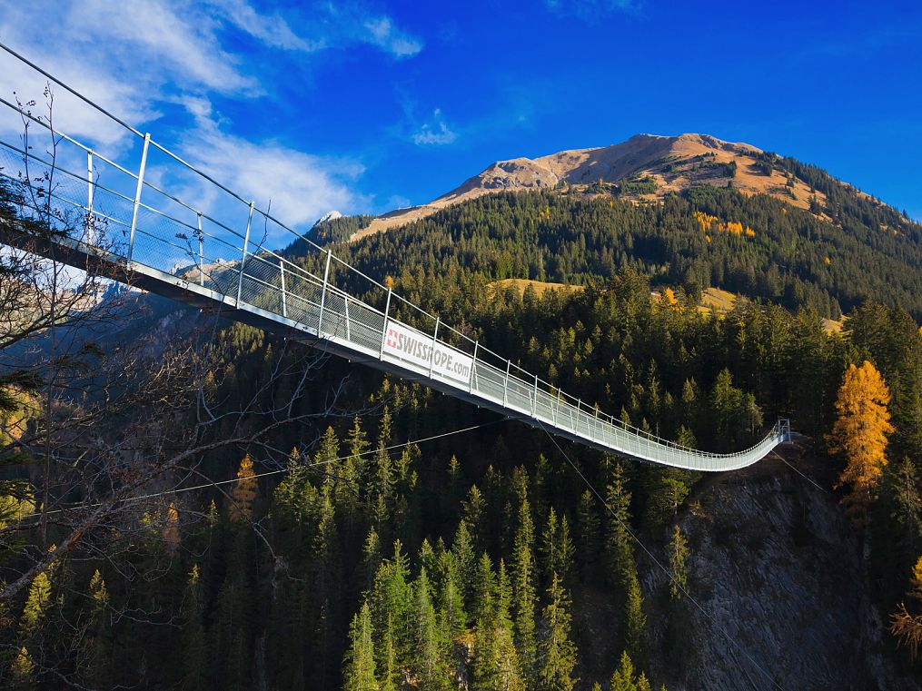Suspension bridge in Holzgau in autumn, surrounded by colourful foliage.