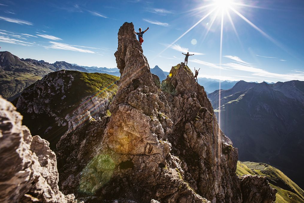 Two people navigate the rocks of the Karhorn Via Ferrata, enjoying the view.