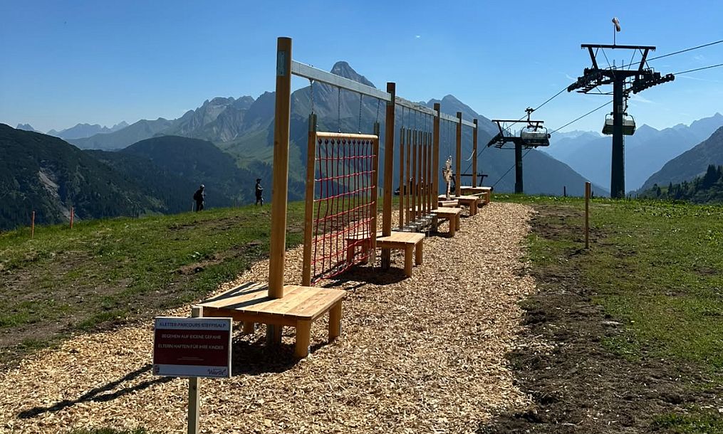 Der Kletterparcours an der Steffisalp ist bei Sonnenschein zu sehen, im Hintergrund befinden sich der Steffisalp-Express und der Biberkopf.