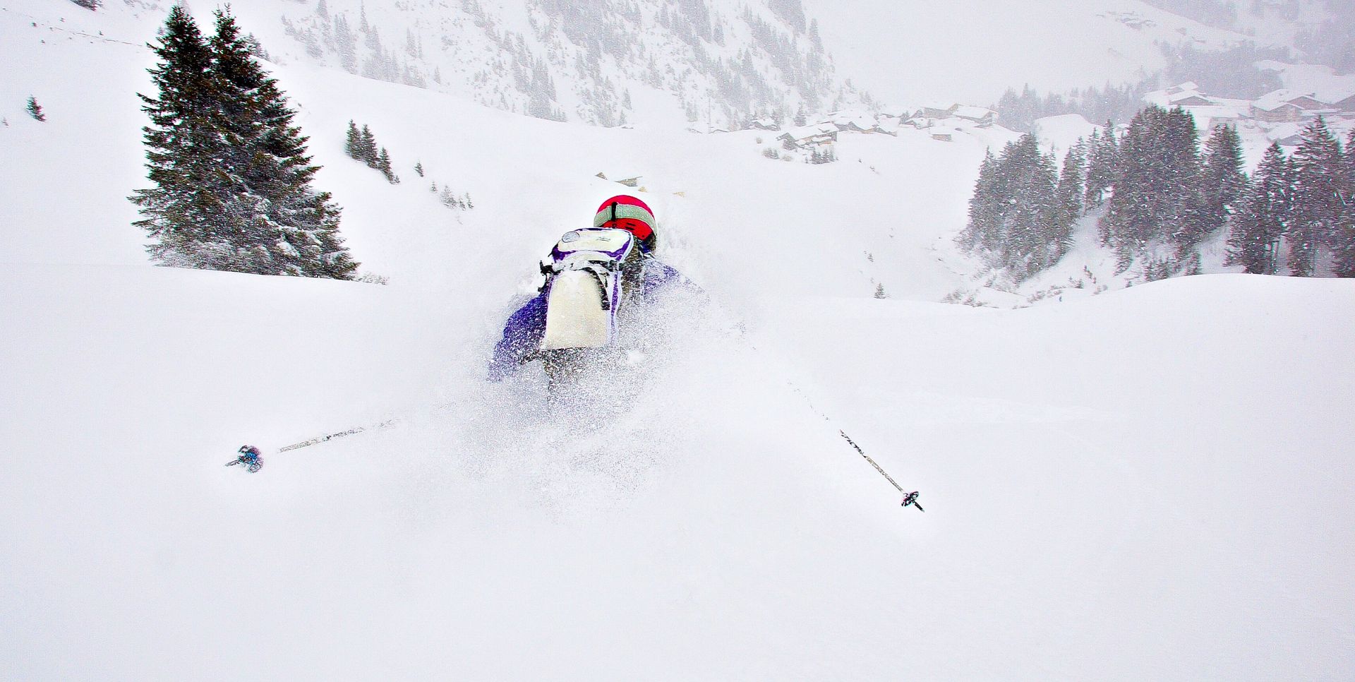 Eine Frau fährt im tiefen Powder die Hänge hinunter in Richtung Warth.