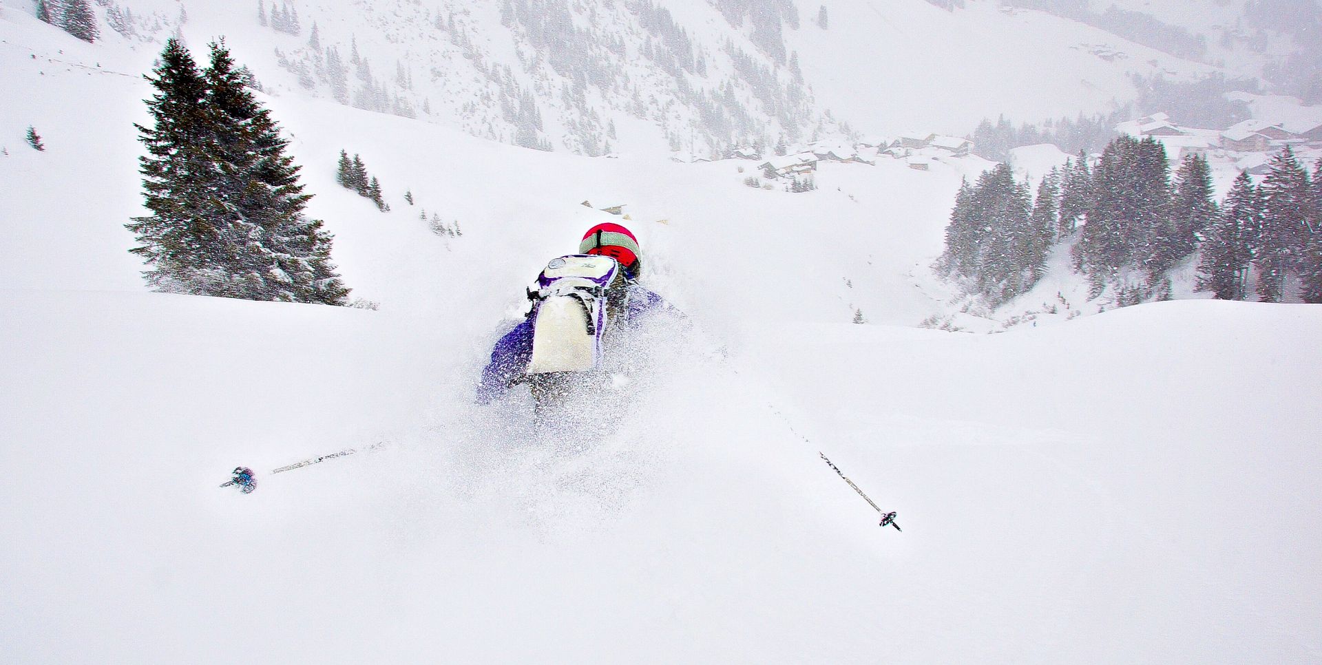 A woman skis down the slopes through deep powder towards Warth.