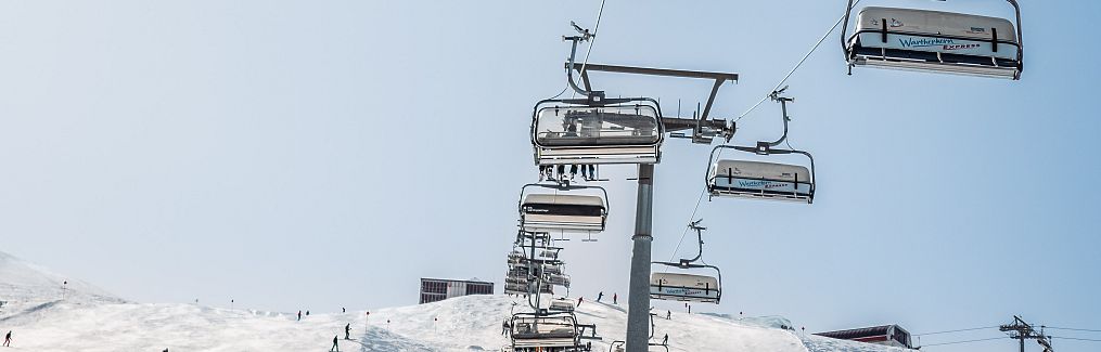 Der Wartherhorn-Express fährt an einem sonnigen, verschneiten Tag.