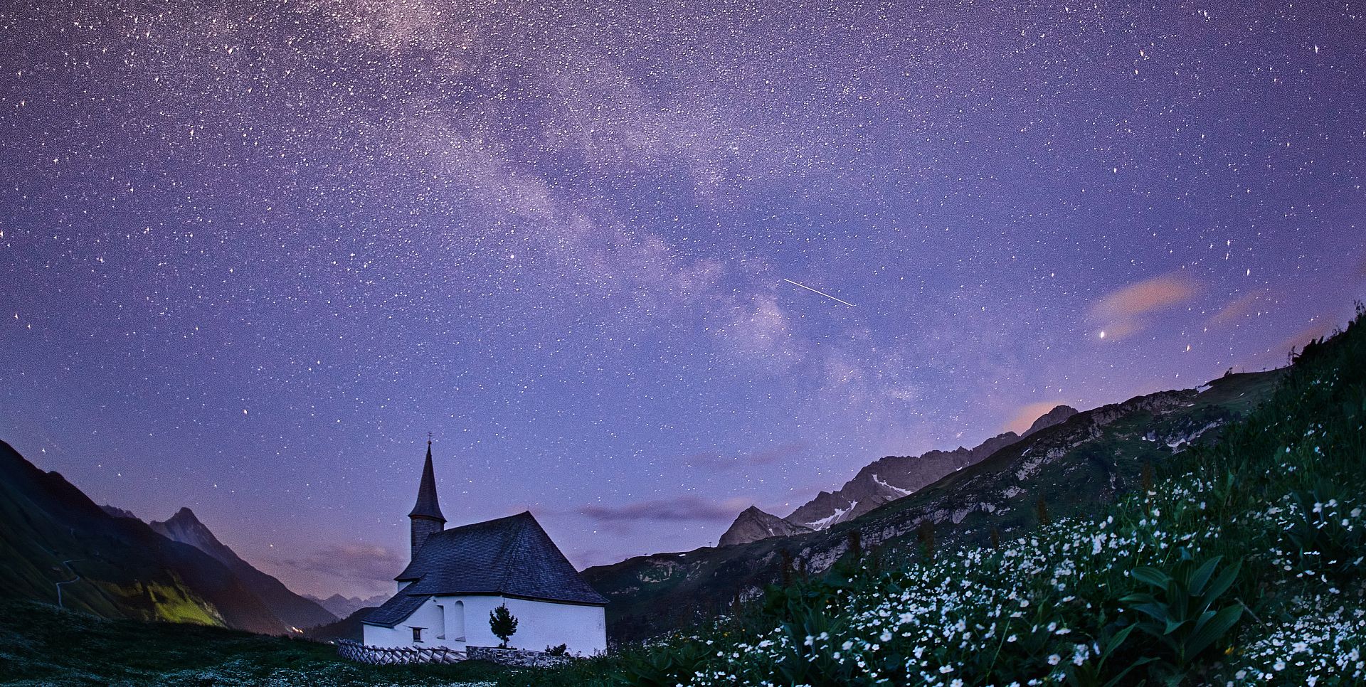 The Simmel Chapel stands in the quiet of night, with the glowing Milky Way stretching above it.