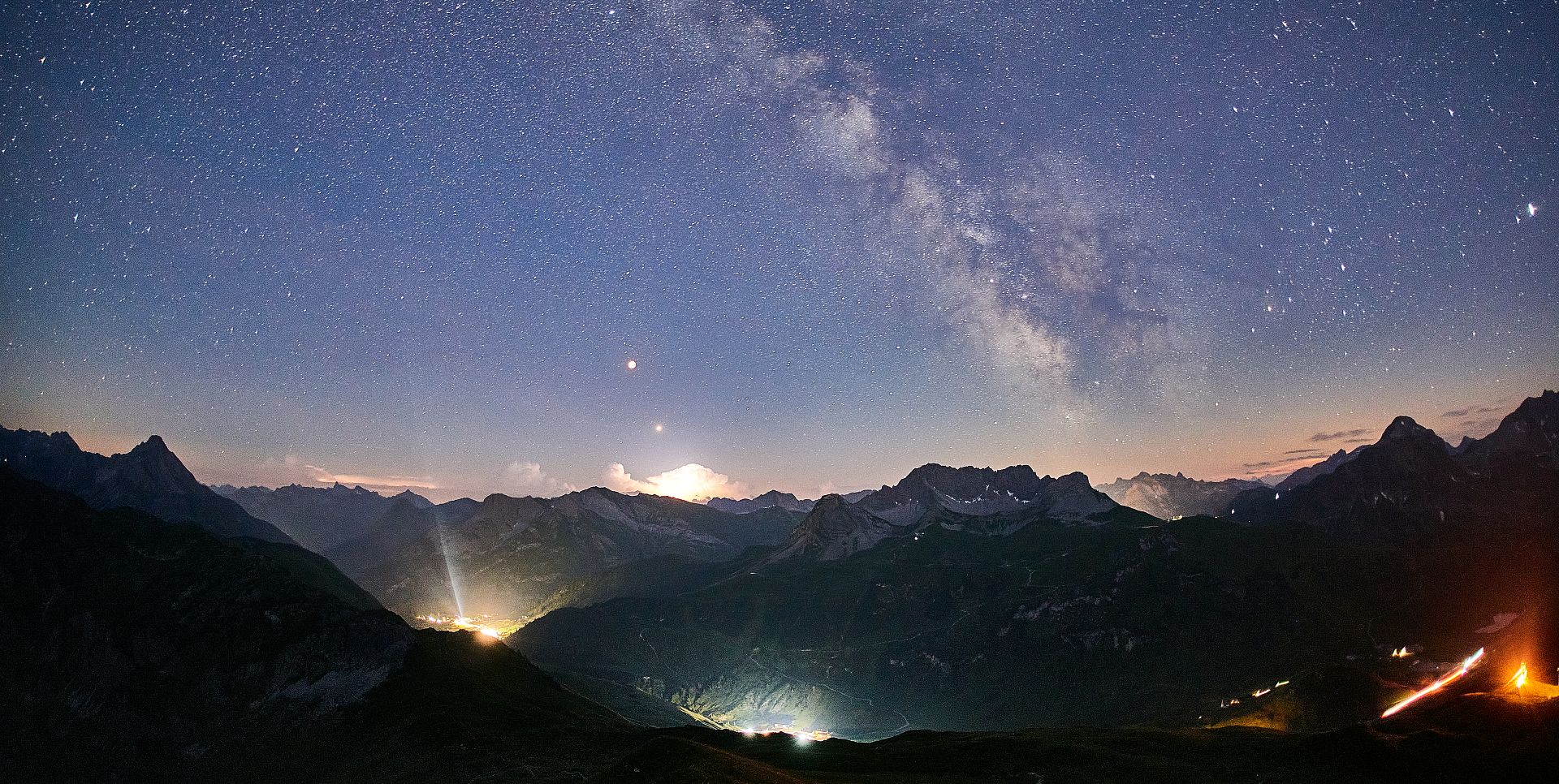 The sparkling Milky Way stretches above the mountain range.
