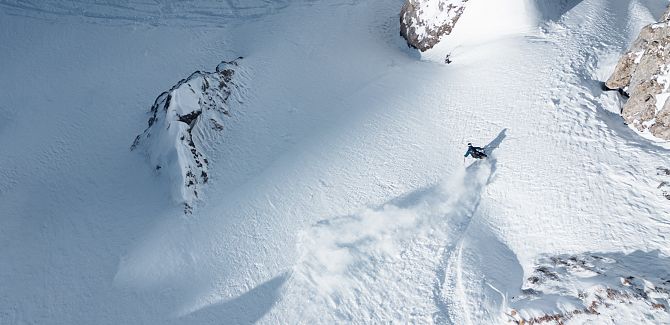 Freerider Martin Winkler fährt durch den Pulverschnee und schlängelt sich zwischen Felsen hindurch.