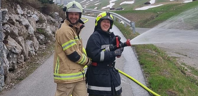 Johannes Strolz takes part in a fire brigade drill, holding the fire hose together with a colleague.