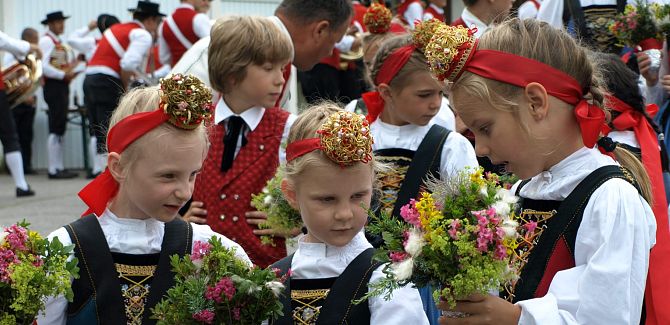 Kindertrachtengruppe Schröcken hält Blumensträuße in den Händen.