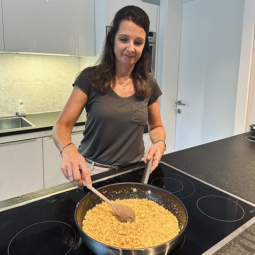 Porträt von Michaela Schwarzmann, die gerade den Riebel in der Pfanne umrührt.
