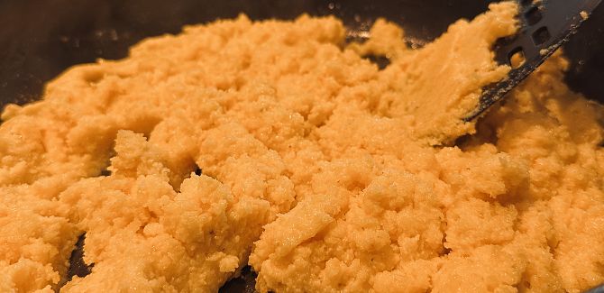 Eine Pfanne, in der der Riebel bereits langsam körniger wird.