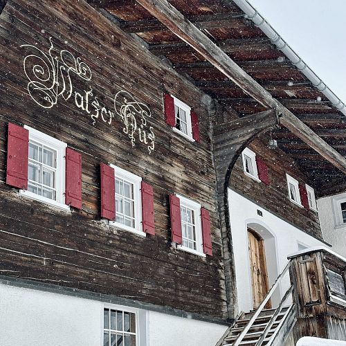 The Walserhus in Warth, with snowflakes falling in the foreground.