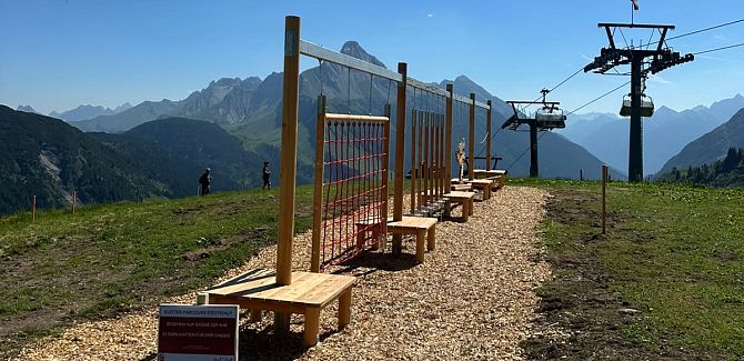 Der Kletterparcours an der Steffisalp ist bei Sonnenschein zu sehen, im Hintergrund befinden sich der Steffisalp-Express und der Biberkopf.