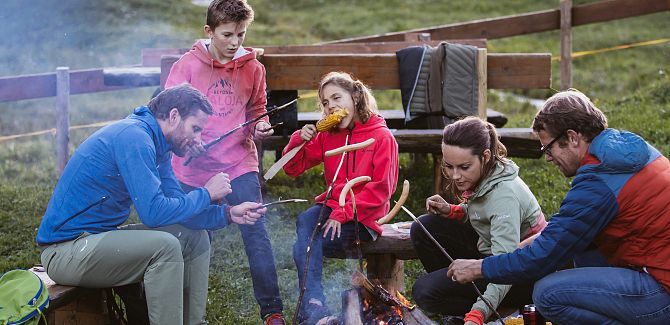 At the Jägeralp barbecue area, a family enjoys the crackling fire and their time together in nature.