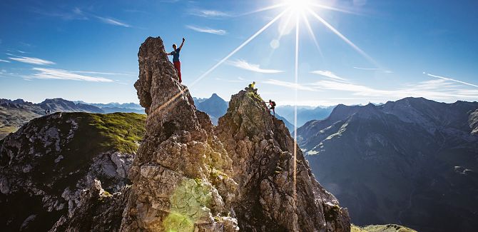 Two people navigate the rocks of the Karhorn via ferrata, enjoying the view.