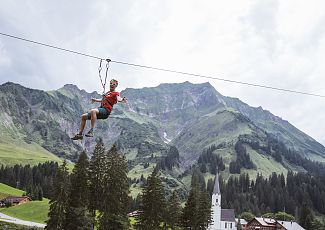 Ein Mann fliegt mit einer Flying Fox über Schröcken.