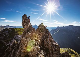 Two people navigate the rocks of the Karhorn via ferrata, enjoying the view.