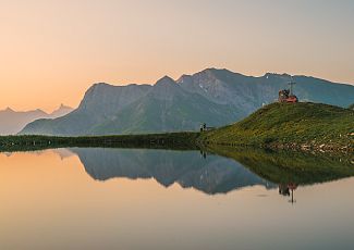 The tranquil Steinmandlsee lies before the impressive backdrop of the Lechtal and Allgäu Alps.