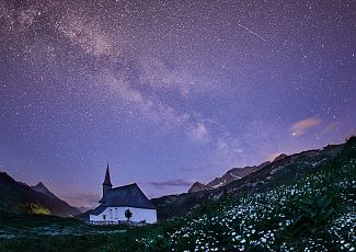 The Simmel Chapel stands in the stillness of the night, with the glowing Milky Way stretching out above it.