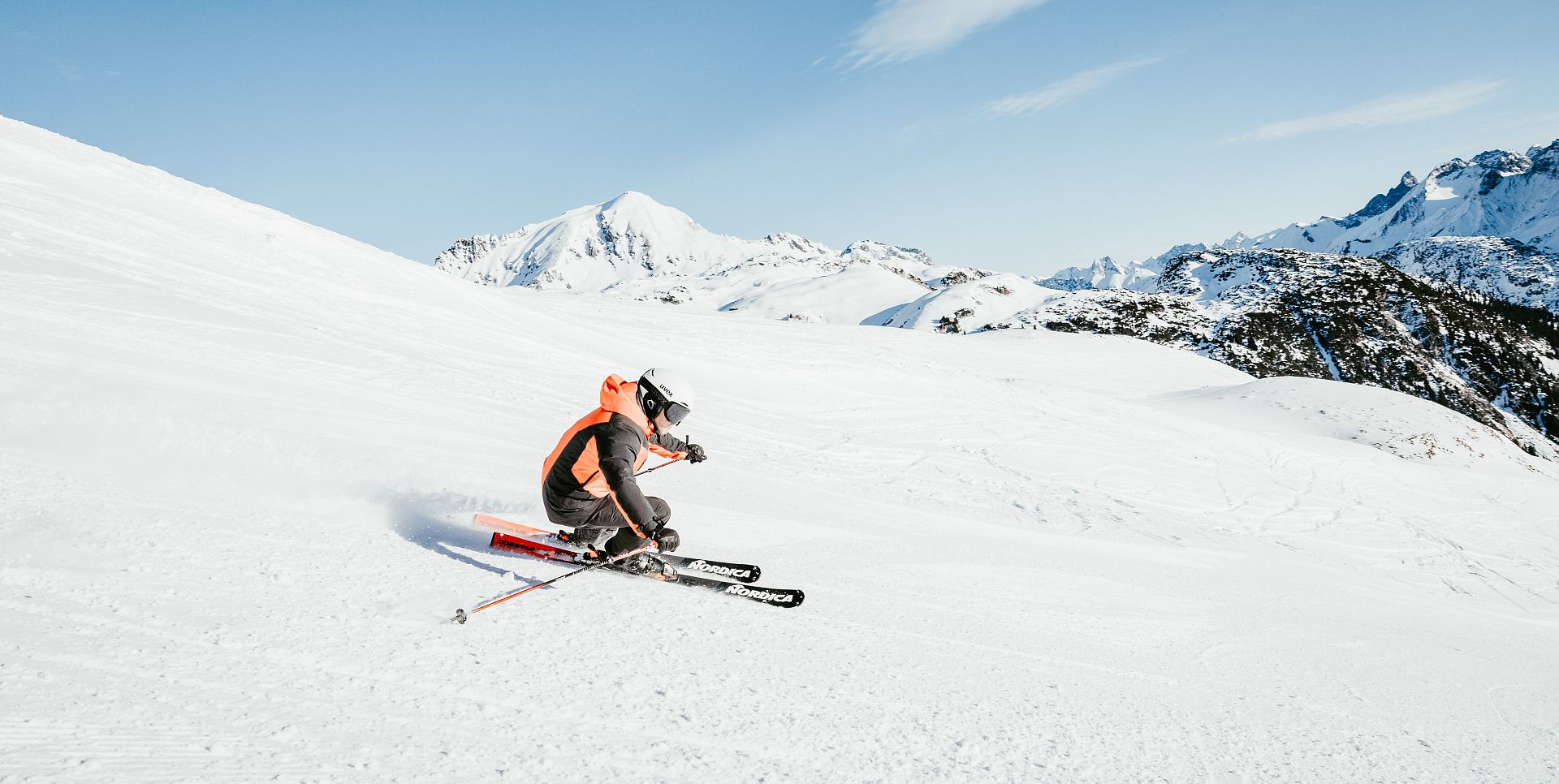 A man glides down the slope of the Wartherhorn in bright sunshine.