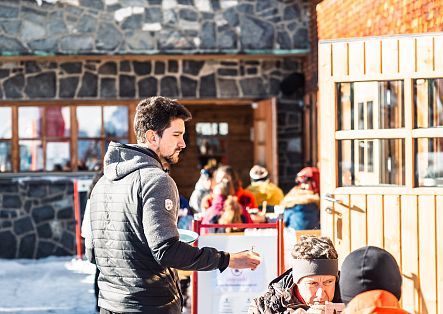 A waiter serves food at the Hochalp hut.