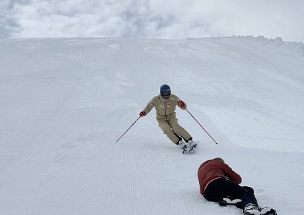 Johannes Strolz poses during a ski photoshoot, while the photographer works on the ground in front of him.
