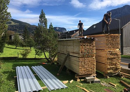 Johannes Strolz helps his brother-in-law lay down wooden boards and beams.