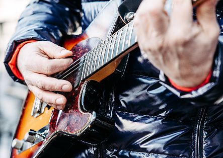 Eine Person spielt E-Gitarre – Detailaufnahme.