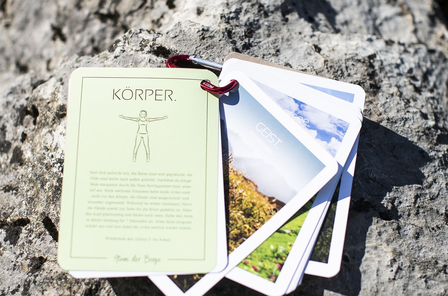 A close-up of a set of mindfulness cards resting on a stone.