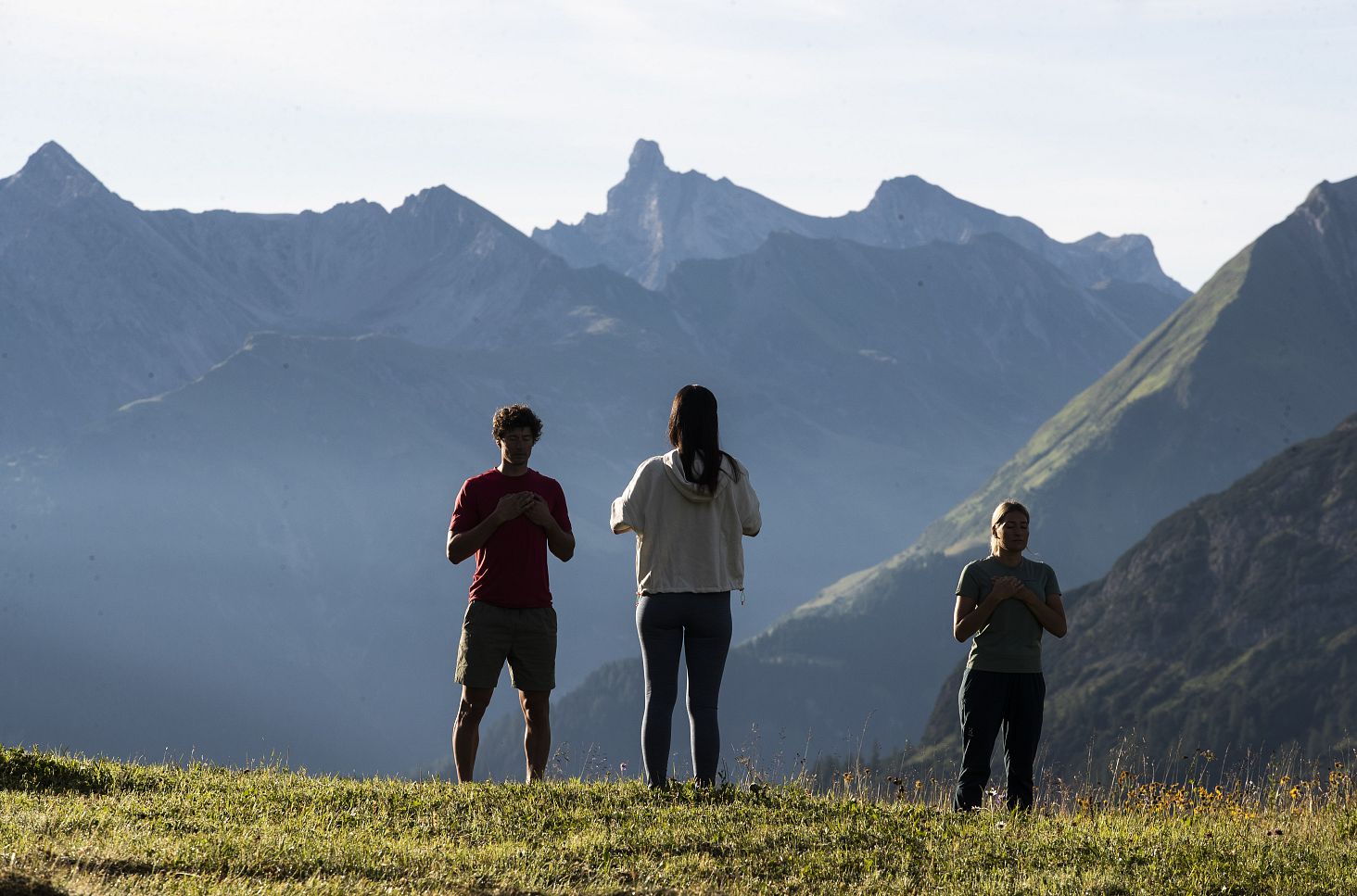A trainer is demonstrating mindfulness exercises on a hill.