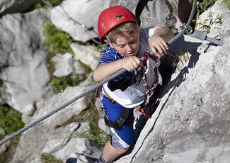 Children climbing on the rock - alpine school Schröcken.